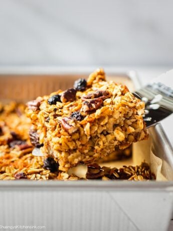 A spatula is serving a piece of freshly baked carrot cake oatmeal bars. This gluten free vegan carrot cake appears to be soft and chewy, perfect for Easter brunch.