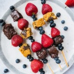 dessert kebabs made with paleo brownies, gluten-free cookie dough, fresh strawberries and blueberries