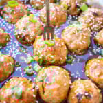 Meatballs are being added into the sticky asian sauce and topped with sesame seeds