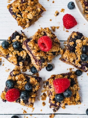 Healthy Blueberry crumble bars topped with fresh blueberries and raspberries