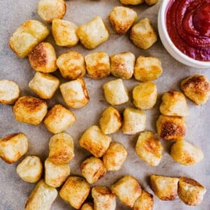 Crispy air fryer cauliflower gnocchi on a parchment paper lined pan with ketchup