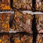 9 pieces of freshly baked and cut brownies with a few pieces of chocolate chips