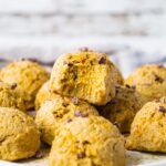 A plate of pumpkin spice energy balls. One of the fat bombs has a bite. The texture is gooey and soft.