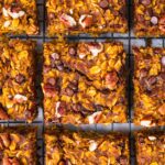 sliced up pumpkin oatmeal bars on a wire drying rack cooling.