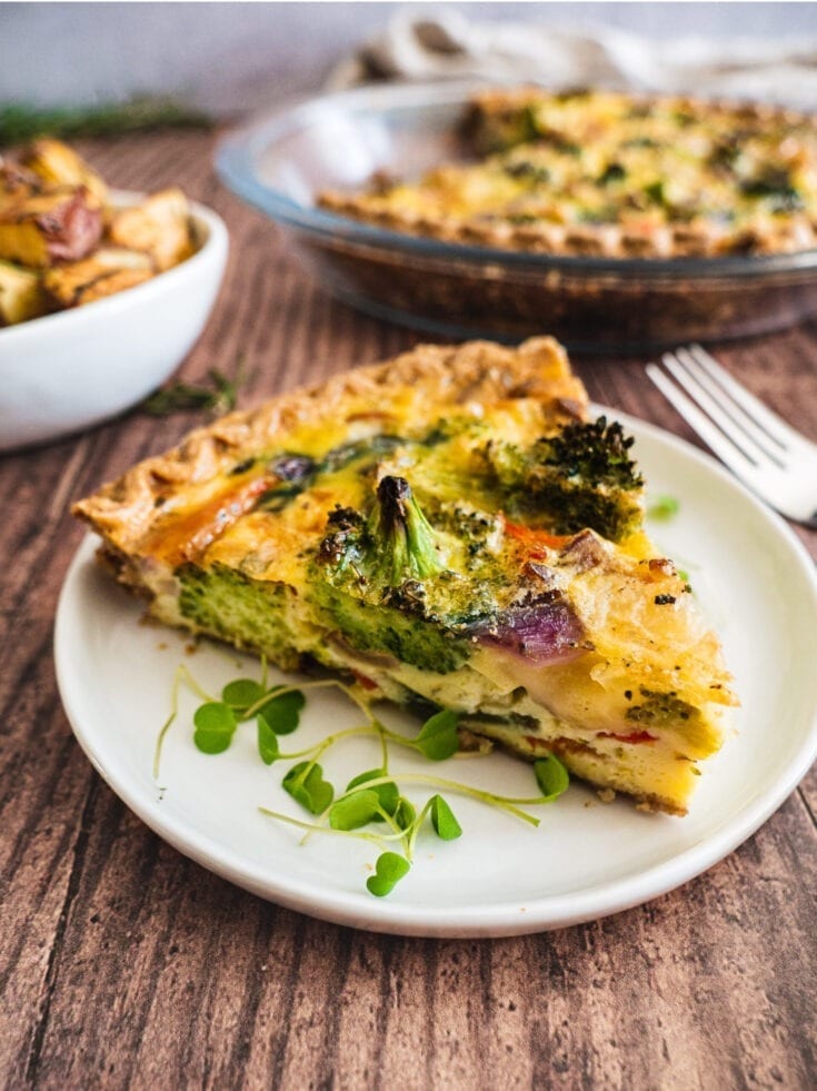 A table full of healthy quiches and rosemary garlic potatoes. There is a fork on the quiche plate.