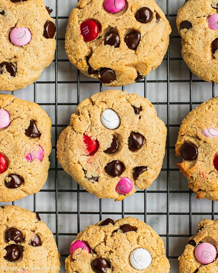 A dozen of M&M chocolate chips cookies are done baking and laying on the cooling rack