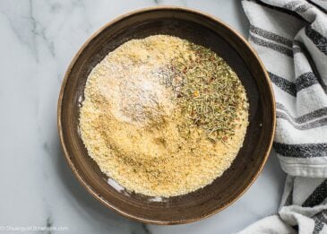 A bowl of breadcrumbs seasoned with italian seasoning and salt pepper.