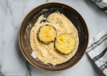 A bowl of eggplants being dipped in breadcrumbs.