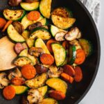 A pan of Zucchini Mushroom Stir Fry. There are zucchini, mushroom, and carrots in them.