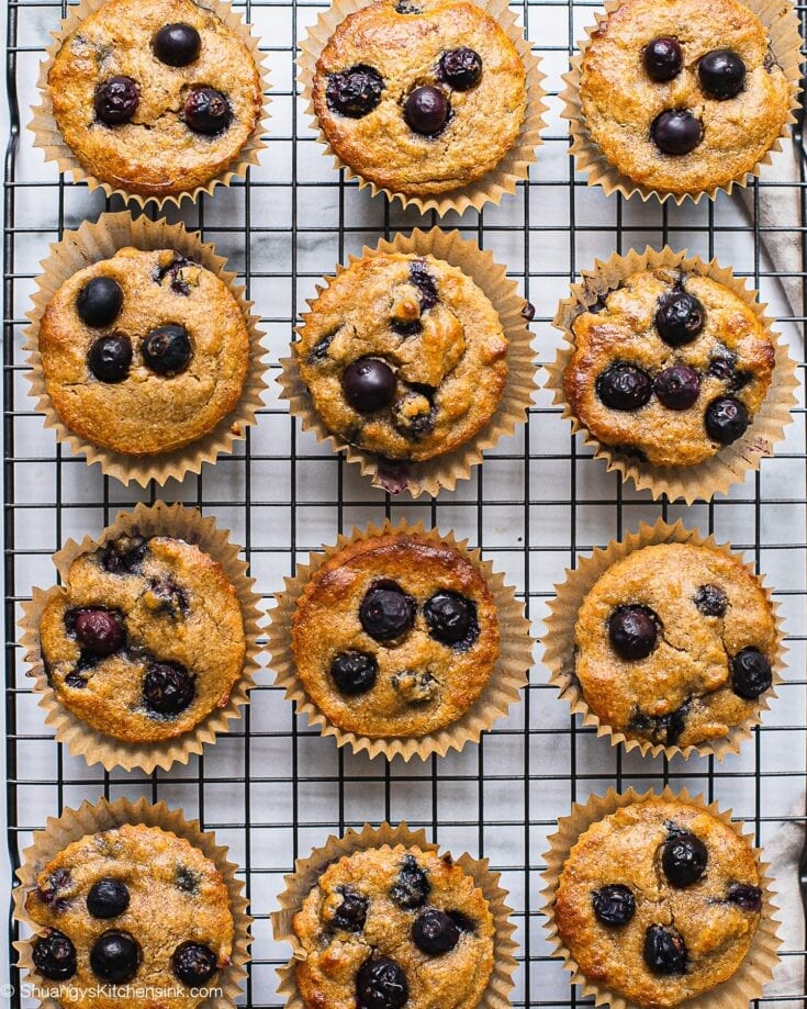 A dozen of healthy blueberry muffins on a cooling rack.