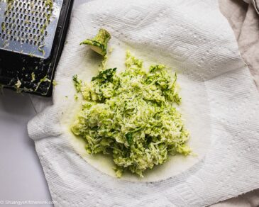 Shredded zucchini being drained on a piece of paper towel