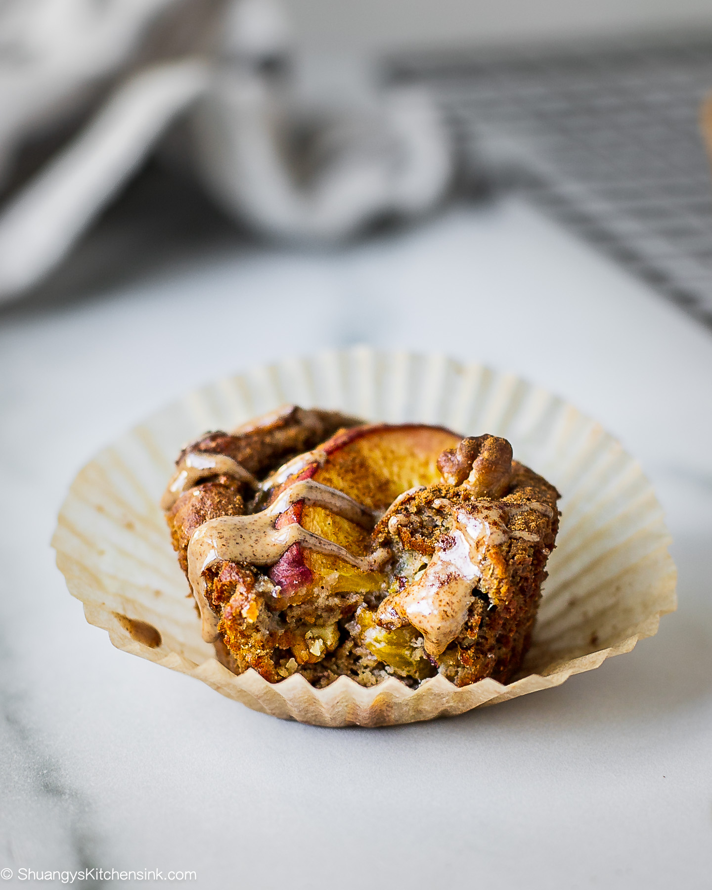 A healthy peach muffin with a bite in it.