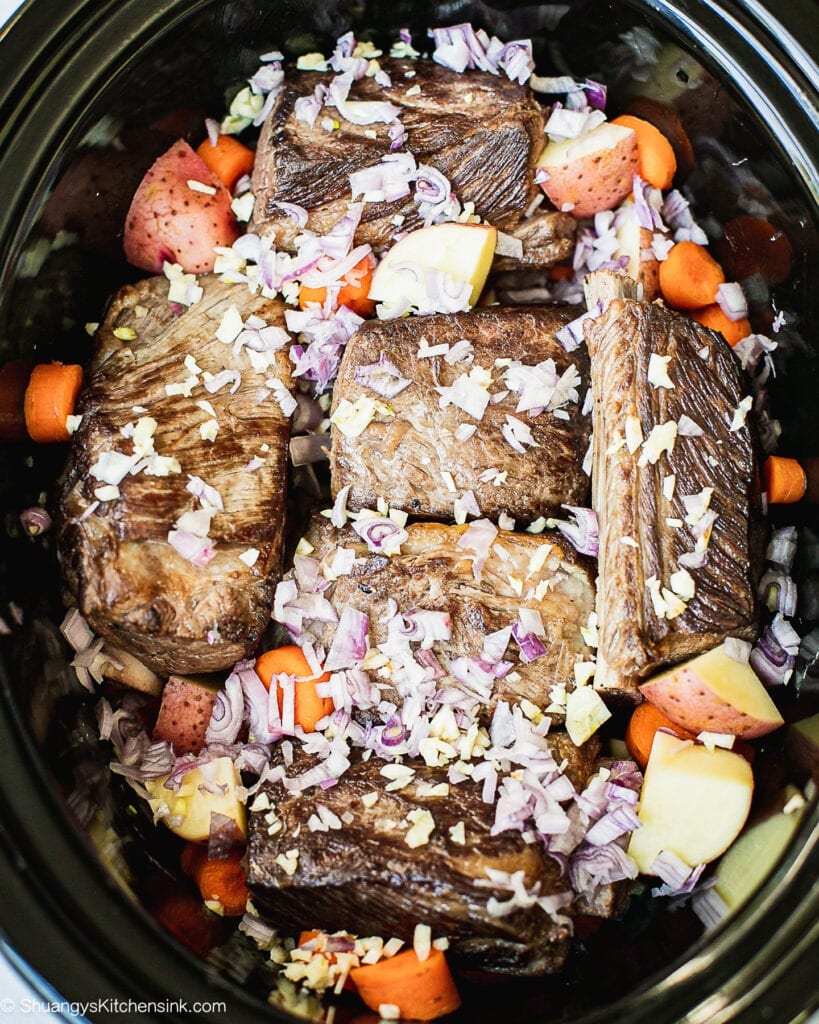 En crockpot med alle ingredienserne til koreanske beef short ribs.