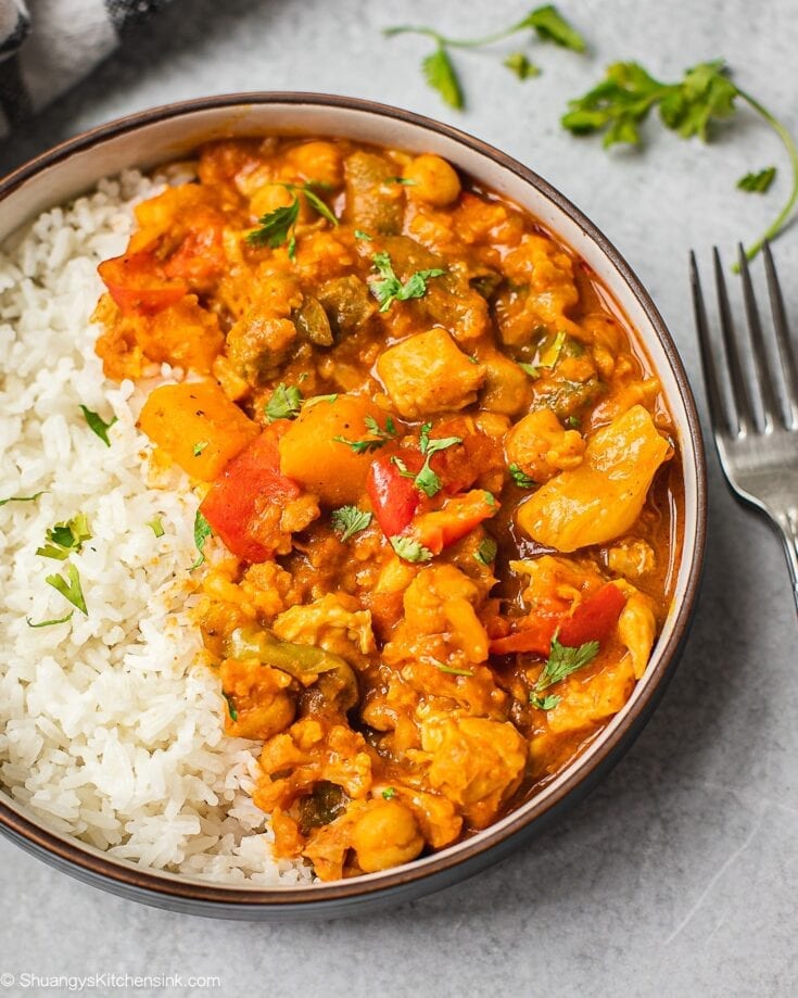 A bowl of pumpkin chickpea curry served on a bed of jasmine rice. Perfect for the chili weather.