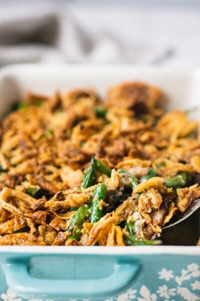 A pan of freshly baked healthy green bean casserole topped with golden brown gluten free crispy onion.
