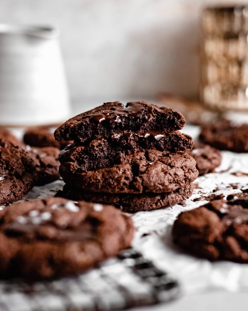 Un teanc de fursecuri cu ciocolată fără gluten. Cel de sus are o mușcătură în el, textura pare a fi moale și asemănătoare cu cea a unui brownie.