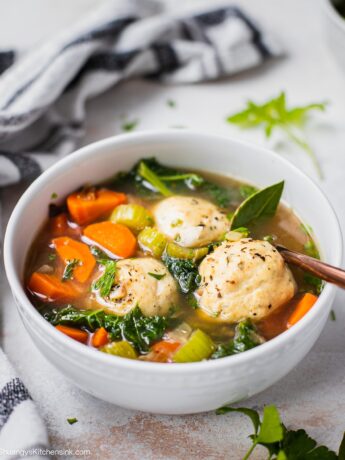 A bowl of healthy Italian Wedding Soup with Baked chicken meatballs, celery, carrots and bay leaves.