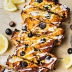A loaf of sliced healthy blueberry lemon bread with coconut butter.