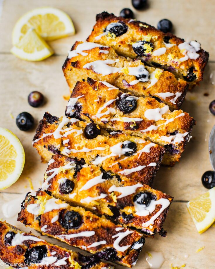 A loaf of sliced healthy blueberry lemon bread with coconut butter.