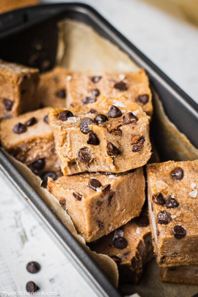 There are a pile of fudgy gluten free no bake cookie dough bites topped with dairy free chocolate chips and flaky salt