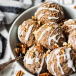 No bake Cinnamon roll cookie dough balls sprinkled with pecans in a round white ball.