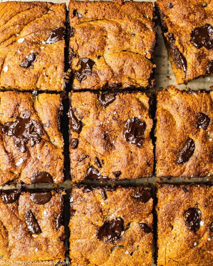 A pan of freshly baked pumpkin pie chocolate chip cookie bars on a cutting board. The healthy bread has been cut into nine squares.