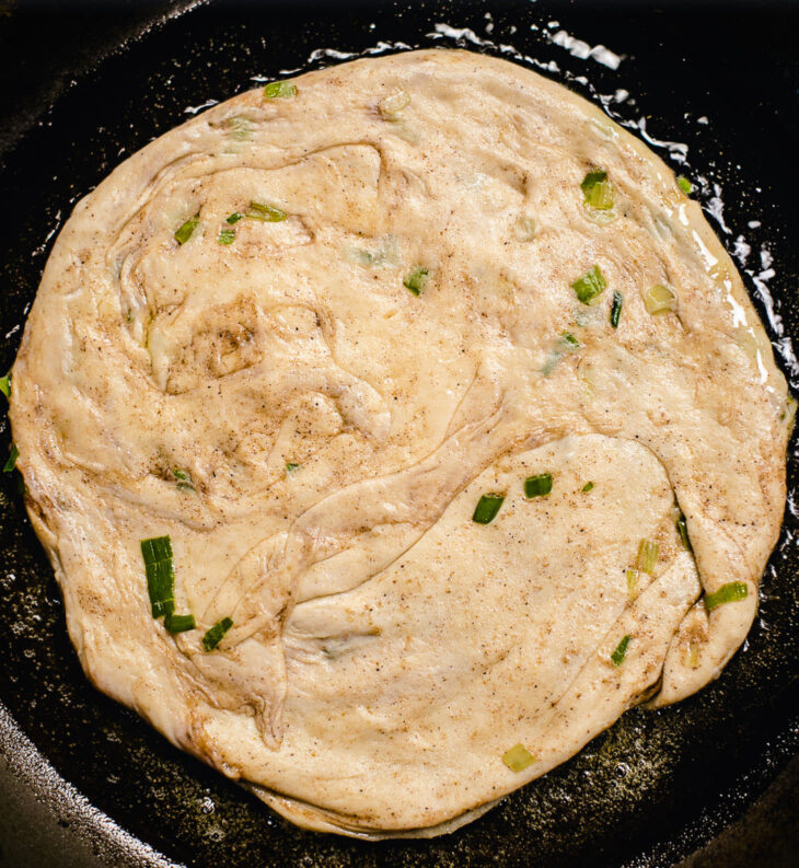 Place the dough in a warm oil-laden pan.