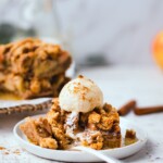 A gluten free apple pie crumble bar topped with vanilla ice cream that's dusted with cinnamon