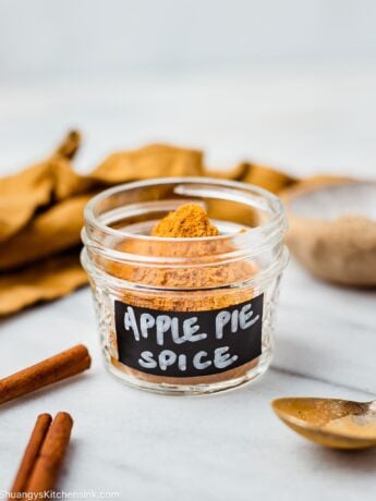 a small mason jar with homemade apple pie spice in it . It is labeled with a black an white hand written note