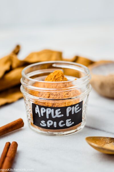 a small mason jar with homemade apple pie spice in it . It is labeled with a black an white hand written note