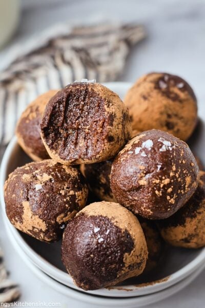 Raw vegan energy brownie alls that has been rolled in cacao powder