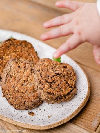 a baby hand is reaching for a healthy gluten free black bean fritter