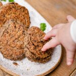 a baby hand is reaching for a healthy gluten free black bean fritter