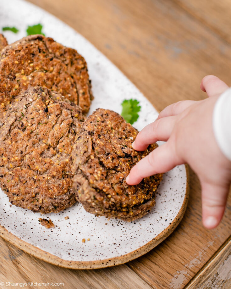 a baby hand is reaching for a healthy gluten free black bean fritter
