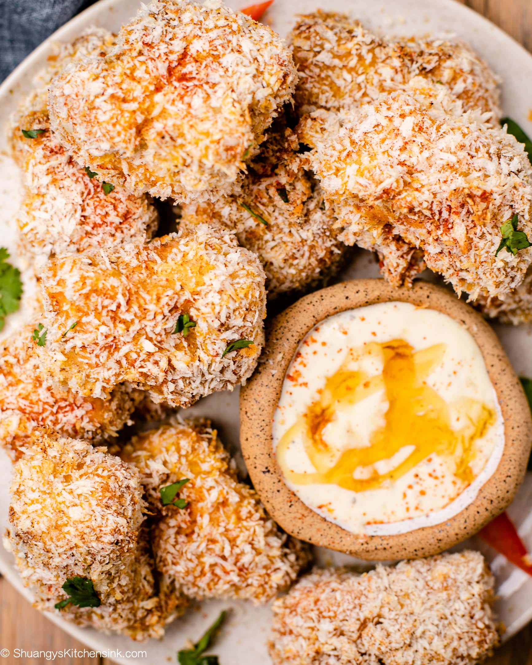 A plate of Salmon nuggets with parsley garnish, and a bowl of chipotle honey dipping sauce