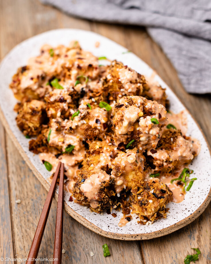 Firecracker tofu made in an air fryer is being served with a homemade spicy vegan sauce