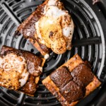 Smores have reached their melty chocolate and marshmallow consistency and are ready to be topped with their top graham cracker