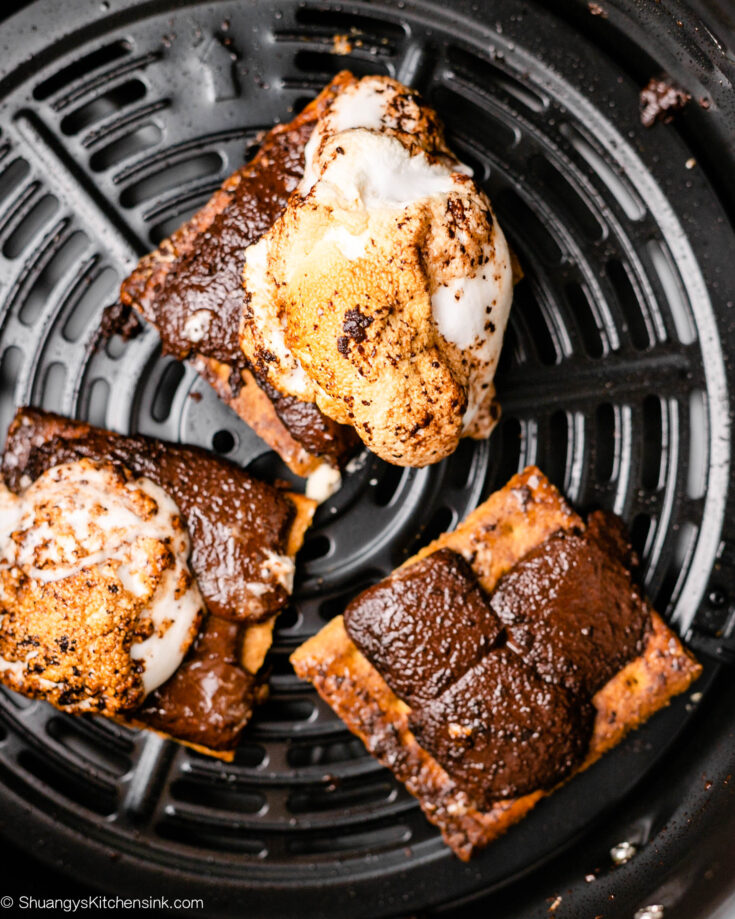 Smores have reached their melty chocolate and marshmallow consistency and are ready to be topped with their top graham cracker