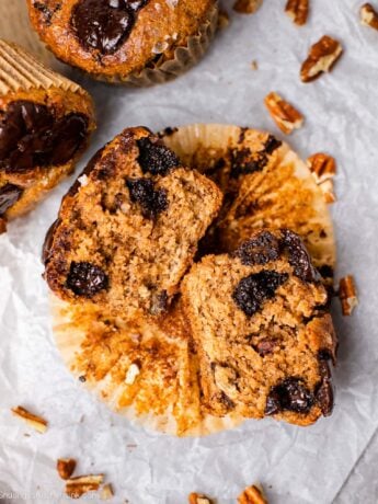 Healthy and easy breakfast muffins made with dark chocolate chips. There are pecans in the background.