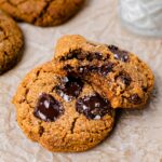image shows the pumpkin chocolate chip cookie stacked on top of each other with a bite taken