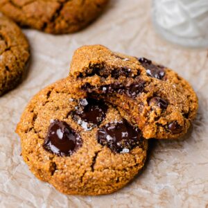 image shows the pumpkin chocolate chip cookie stacked on top of each other with a bite taken