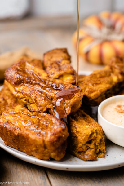 Pumpkin French toast sticks being drizzled with maple syrup