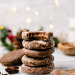 Delicious No Bake Gingerbread Cookies are stacked on parchment paper with a bite taken out of one