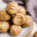a bite is taken from one of the birthday cake protein ball