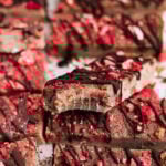 Freeze Dried Strawberry bars have chocolate drizzled on top and a bite taken out of them.