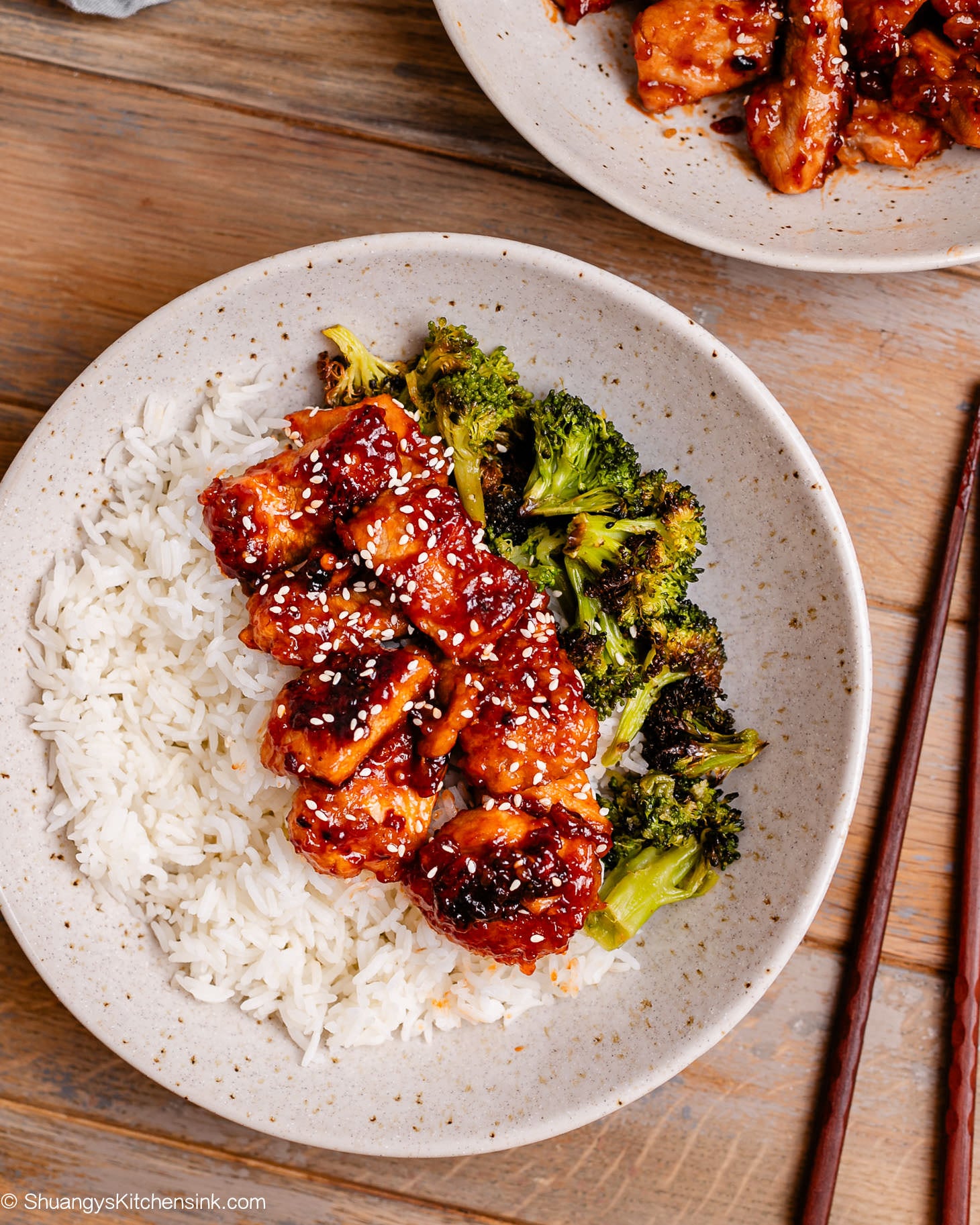 Crispy golden-brown sweet and sour pork strips coated in sticky honey-ketchup sauce, served with broccoli and sesame seeds.