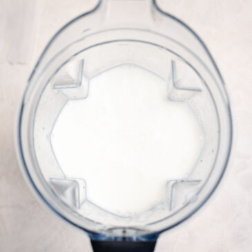 Milk added to a high-speed blender as the base liquid for a homemade kids green smoothie recipe.