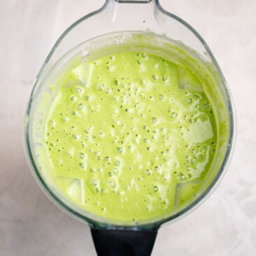 Top view of a creamy kids green smoothie with spinach and fruit blended until smooth and frothy in a high-speed blender.