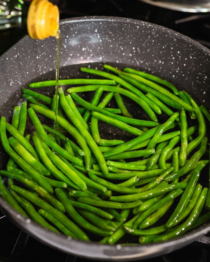 Step by step instruction to make stir fried green beans and pork mince - In a deep pot, add the green beans along with a little oil and salt. Bring to a boil.