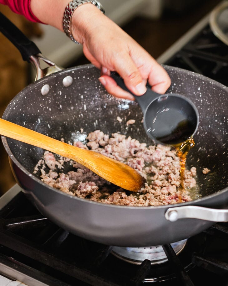 Heat oil in a wok, then add the ground pork. Stir in coconut aminos and Shaoxing wine.